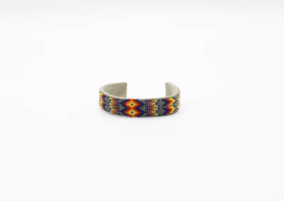 Beaded bracelet with colorful geometric pattern on a white background.