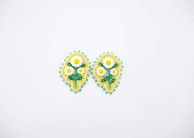 Colorful handmade beaded earrings with floral designs featuring yellow and white daisies, surrounded by green accents.