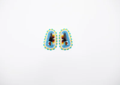 Colorful handmade Native American-style earrings featuring geometric designs and vibrant beads against a white background.